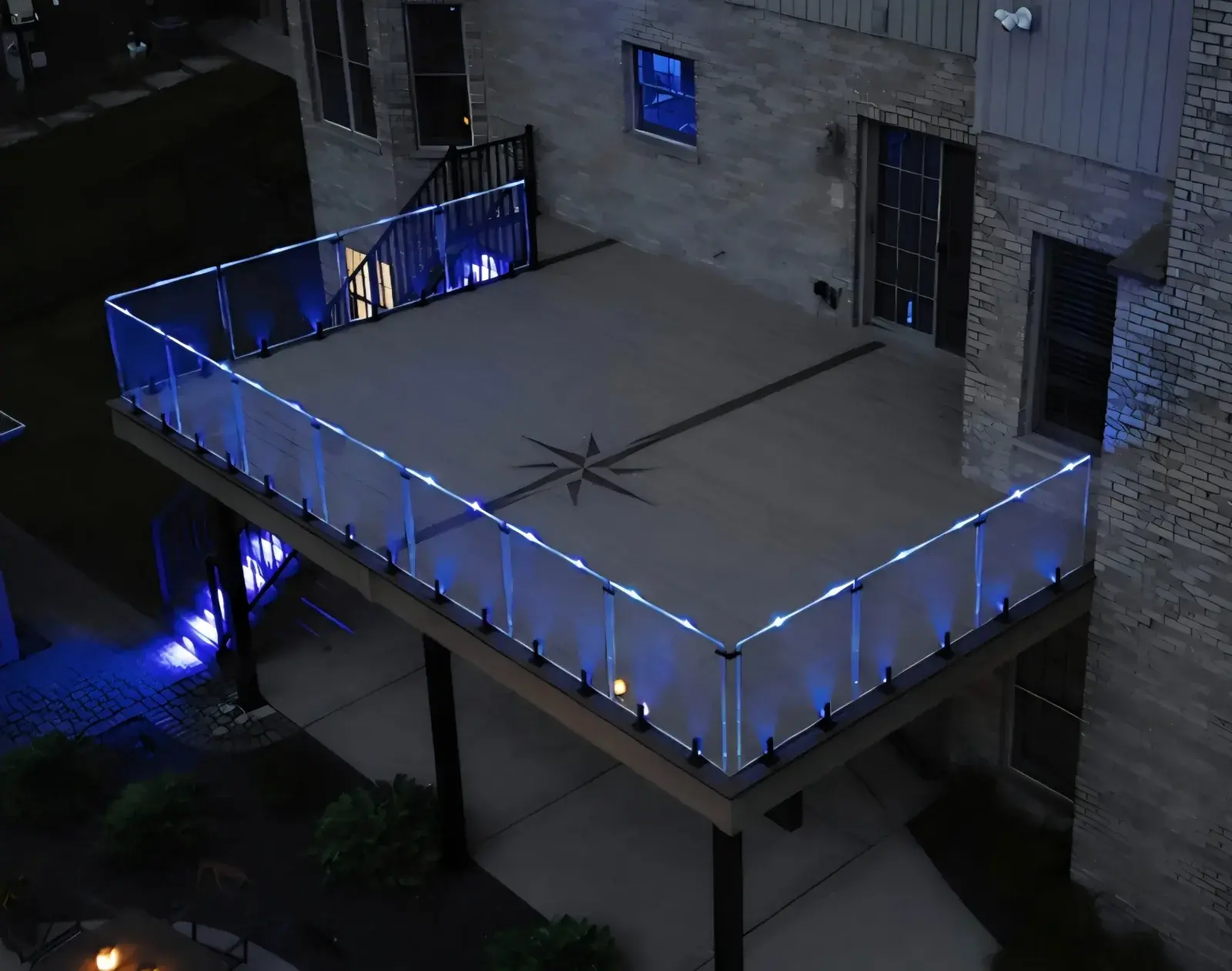 Second-story balcony with blue LED glass spigot railing at night