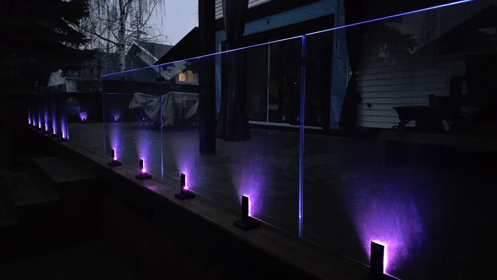 Glass spigot railing glowing purple at dusk