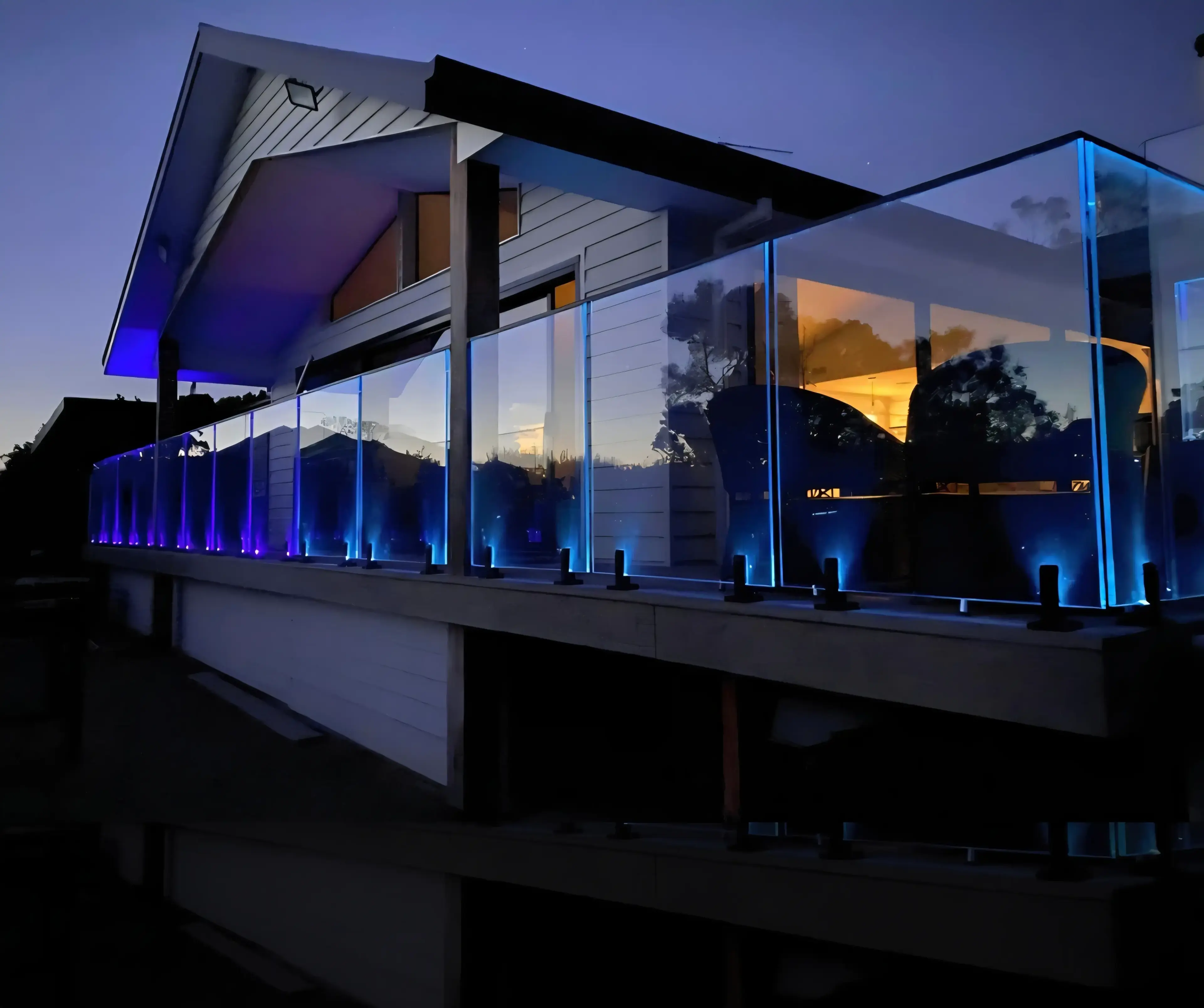 LED glass spigots illuminating a modern glass railing at night